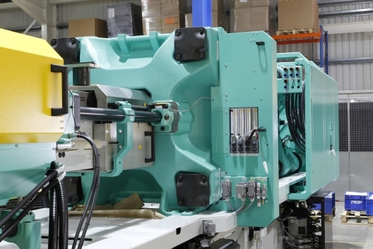 An injection molding machine on a plastics factory floor